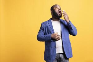 africain américain homme sentiment épuisé et bâillement, couvrant le sien bouche, isolé plus de studio Contexte. bipoc la personne étant somnolent pendant matin, éveiller aussi tôt, montrant envie de dormir photo