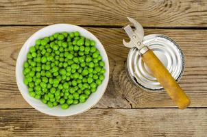 bol en bois avec des pois verts en conserve sur la table. photo