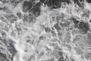 Extérieur l'eau mousse tourbillonne toile de fond. mer vague mousse texture. Marin aqua mouvement surface Contexte. photo