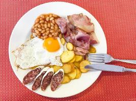 bacon, haricots, œuf au plat, saucisses, pommes de terre, petit-déjeuner anglais. photo