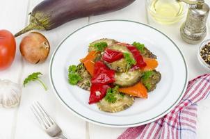 ragoût d'aubergine, paprika, oignon et ail sur table en bois blanc. photo