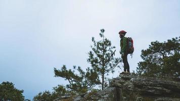 femme asiatique voyage nature. voyager se détendre. tenez-vous debout et regardez les paysages naturels sur la falaise. vacances à la montagne. admirez le paysage d'ambiance sur la montagne. photo