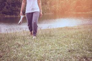 les femmes asiatiques se détendent pendant les vacances. marcher pied sur le pré photo