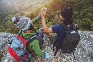 les femmes et les hommes amoureux asiatiques voyagent dans la nature. voyage se détendre. asseyez-vous et regardez la vue sur la montagne. sur une falaise sur la montagne. Thaïlande photo