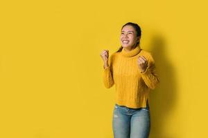 portrait d'une femme asiatique heureuse criant un succès excité et célébrant isolé sur fond jaune. réussir photo