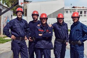 une équipe de sur de soi et accompli sapeurs pompiers enjambées volontairement dans leur uniformes, exsudant fierté et la satisfaction après avec succès compléter une difficile lutte contre les incendies mission photo