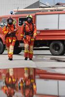 une équipe de sur de soi et accompli sapeurs pompiers enjambées volontairement dans leur uniformes, exsudant fierté et la satisfaction après avec succès compléter une difficile lutte contre les incendies mission photo