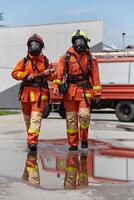 une équipe de sur de soi et accompli sapeurs pompiers enjambées volontairement dans leur uniformes, exsudant fierté et la satisfaction après avec succès compléter une difficile lutte contre les incendies mission photo