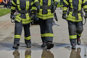 une équipe de sur de soi et accompli sapeurs pompiers enjambées volontairement dans leur uniformes, exsudant fierté et la satisfaction après avec succès compléter une difficile lutte contre les incendies mission photo