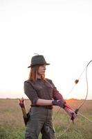 femme avec un arc à l'extérieur sur le terrain photo