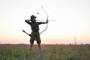 femme avec un arc à l'extérieur sur le terrain photo