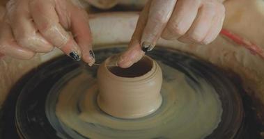 Close up of womans travail à la main avec de l'argile en studio de poterie photo