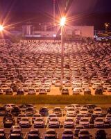 Volkswagen, Russie, kaluga - août 26, 2020 Nouveau voitures garé à Distribution centre voiture usine à nuit avec lumières. parking sur le ouvert air. photo