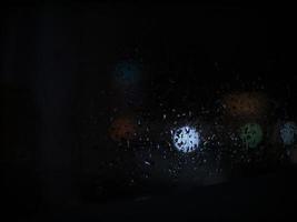 gouttes de pluie sur le verre en arrière-plan de la nuit photo