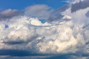 de gros nuages blanc-gris se condensent en nuages pluvieux capturant progressivement le ciel bleu, en gros plan.