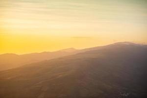 paysage lever de soleil sur la montagne avec champ et prairie d'herbe beau ciel jaune ou coucher de soleil. photo