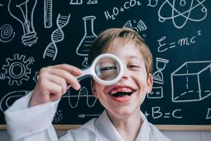 enfant heureux regardant la caméra à travers une loupe photo