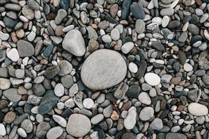 motif de gravier de pierres colorées. fond de cailloux de nature abstraite. fond de pierre. plage de galets de la mer. vue de dessus. photo