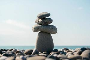 pyramide de pierres sur la plage de galets symbolisant la stabilité, le zen, l'harmonie, l'équilibre photo