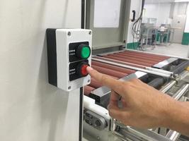 Toucher la main sur la machine à bouton en usine industrielle photo