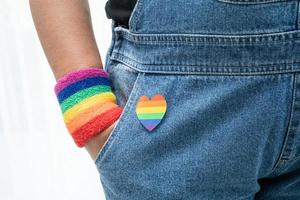 une dame asiatique portant des bracelets de drapeau arc-en-ciel, symbole du mois de la fierté lgbt, célèbre chaque année en juin les droits des homosexuels, lesbiennes, bisexuels, transgenres et humains. photo