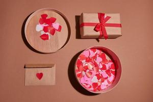 composition de la Saint-Valentin. coffret, confettis, enveloppe carte postale avec coeur rouge sur fond pastel photo