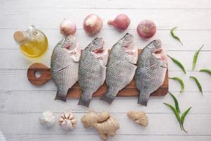 poisson frais cru sur une planche à découper pour préparer la cuisson sur table , photo