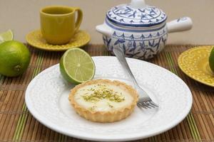 vue latérale d'une tarte au citron sur une assiette avec des tranches de citron sur la table. photo