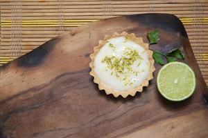 vue de dessus de la tartelette avec crème au citron et chips d'agrumes sur la vieille table en bois, espace de copie. mise au point sélective. photo