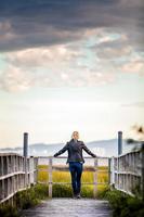 jeune femme solitaire regardant l'incroyable paysage calme depuis un balcon en bois photo