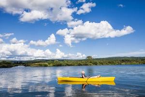 rivière calme et femme relaxante en kayak photo