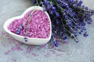 bol en forme de coeur avec du sel de mer et des fleurs de lavande fraîche photo