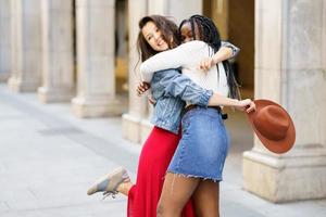 deux amis heureux de se voir dans la rue en train de s'embrasser. photo