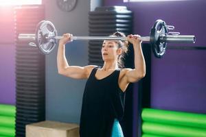femme athlétique dans la salle de gym soulever des poids à la salle de sport photo