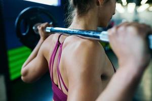 femme athlétique dans la salle de gym soulever des poids à la salle de sport photo