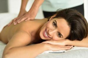 jeune femme recevant un massage relaxant du dos dans un centre de spa. photo