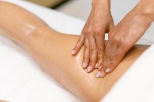 professionnel de salon de beauté versant de l'huile d'une bougie de massage sur le dos de son patient. photo