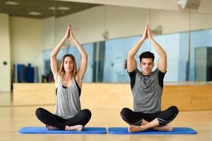 jeune femme et homme pratiquant le yoga à l'intérieur photo