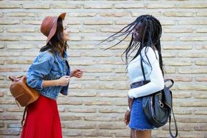 deux amies s'amusant ensemble dans la rue. amis multiethniques. photo