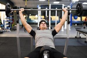 bodybuilder jeune homme faisant de l'haltérophilie dans la salle de gym. photo