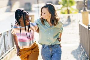 deux amis discutant ensemble dans la rue. femmes multiethniques. photo