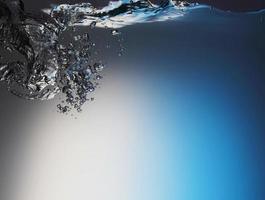 Résumé des éclaboussures de vague d'eau transparente bleue avec des bulles d'eau sur le bleu. photo