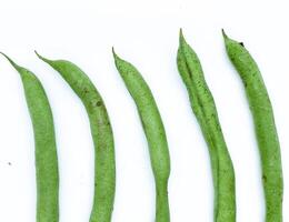 haricots verts isolés sur fond blanc. des haricots longs frais pour une cuisine polyvalente. un légume vert qui peut être une cuisine savoureuse après cuisson. photo