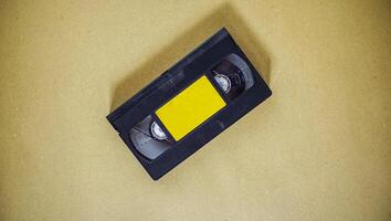 une vieille cassette audio a une étiquette jaune. trucs pour enregistrer et stocker des données dans un format sonore. un média à l'ancienne à des fins de divertissement. photo