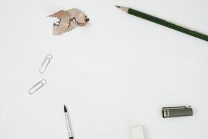 espace vide pour le lettrage. copiez l'espace pour montrer le projet d'écriture manuscrite. un bureau vide avec un fond blanc du point de vue supérieur. la papeterie entoure l'espace. photo