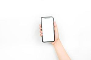 tenant un smartphone à deux mains comme s'il tapait une conversation. un smartphone avec un écran blanc vierge utilisé pour la maquette publicitaire. photo