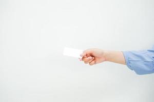 une main d'une dame portant une longue chemise bleue tenant un espace blanc vide comme veut donner une carte à quelqu'un. une maquette adaptée à une utilisation commerciale ou d'une maquette d'identité. photo
