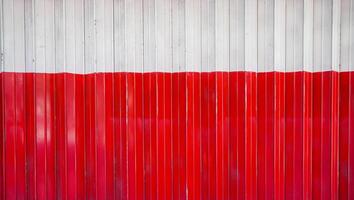 l'aspect détaillé de la porte pliante rouge et blanche. la vue rapprochée de l'atelier fermé à l'aide d'une porte pliée. le fond texturé du matériau de la rue. photo