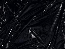 une pellicule plastique transparente sur fond noir. texture réaliste d'enveloppe en plastique pour la superposition et l'effet. motif en plastique froissé pour un design créatif et décoratif. photo