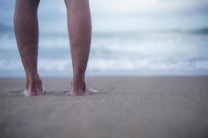 profitez du doux clapotis des vagues pieds nus. aller à la plage pour profiter du temps des vacances en se relaxant dans l'eau de mer et les plages de sable. photo